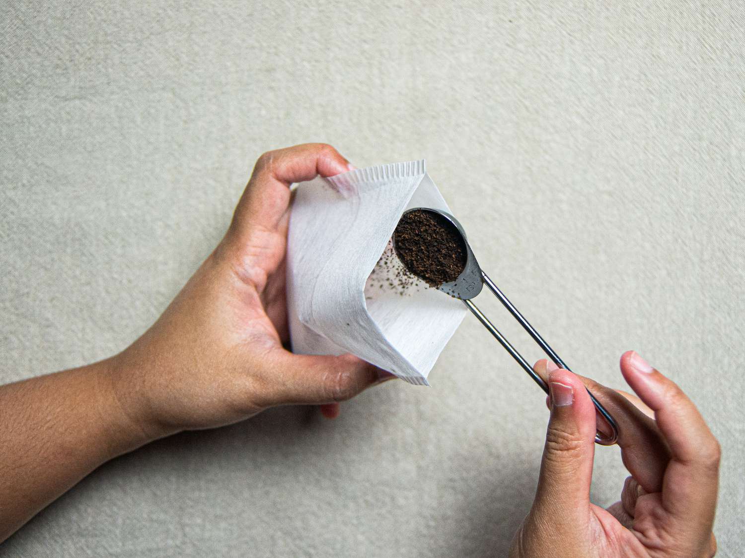 Overhead view of adding tea to a tea bag