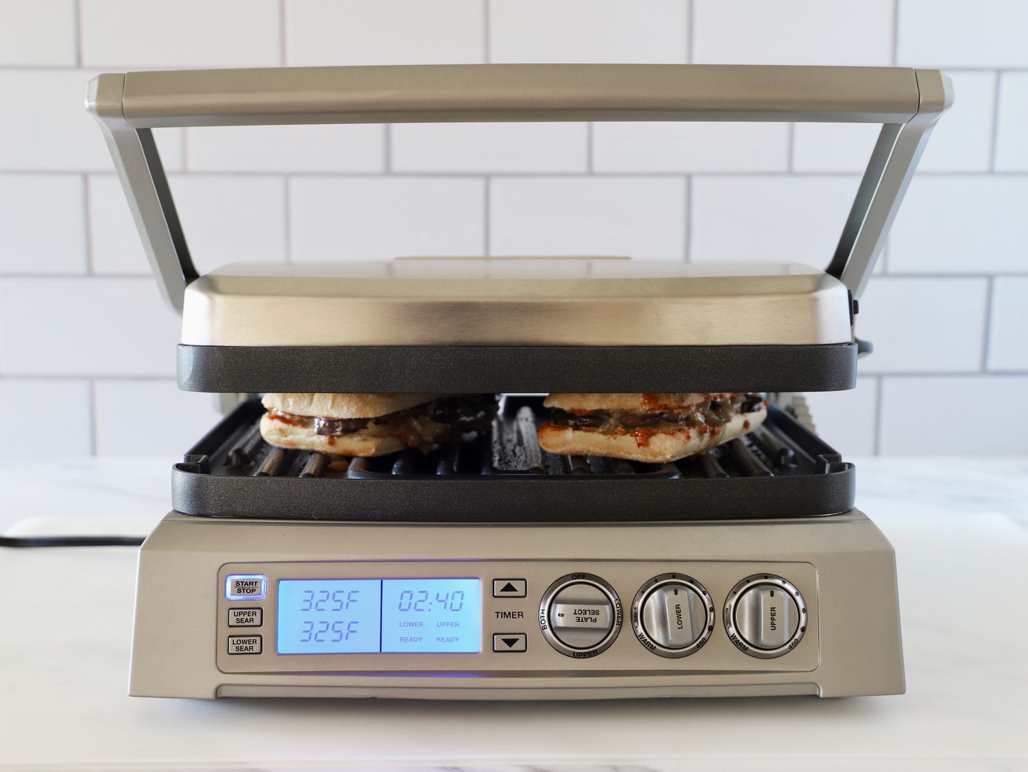 a panini press with its lid closed and pressing two sandwiches