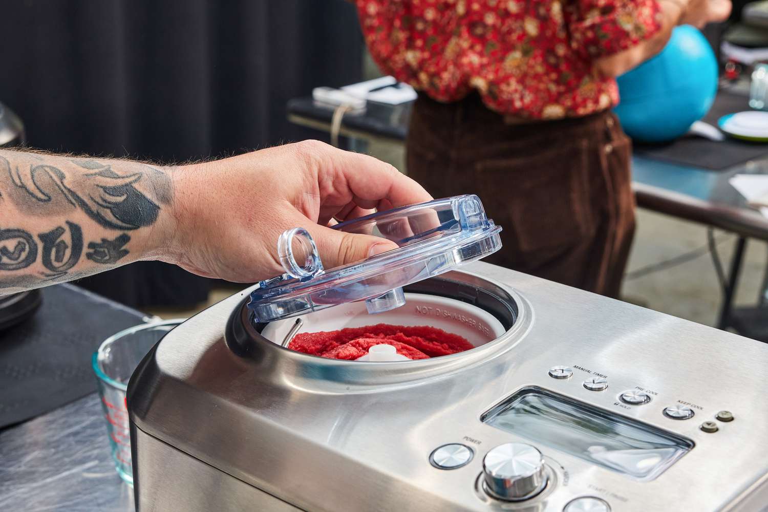 a person removing the lid of an ice cream maker