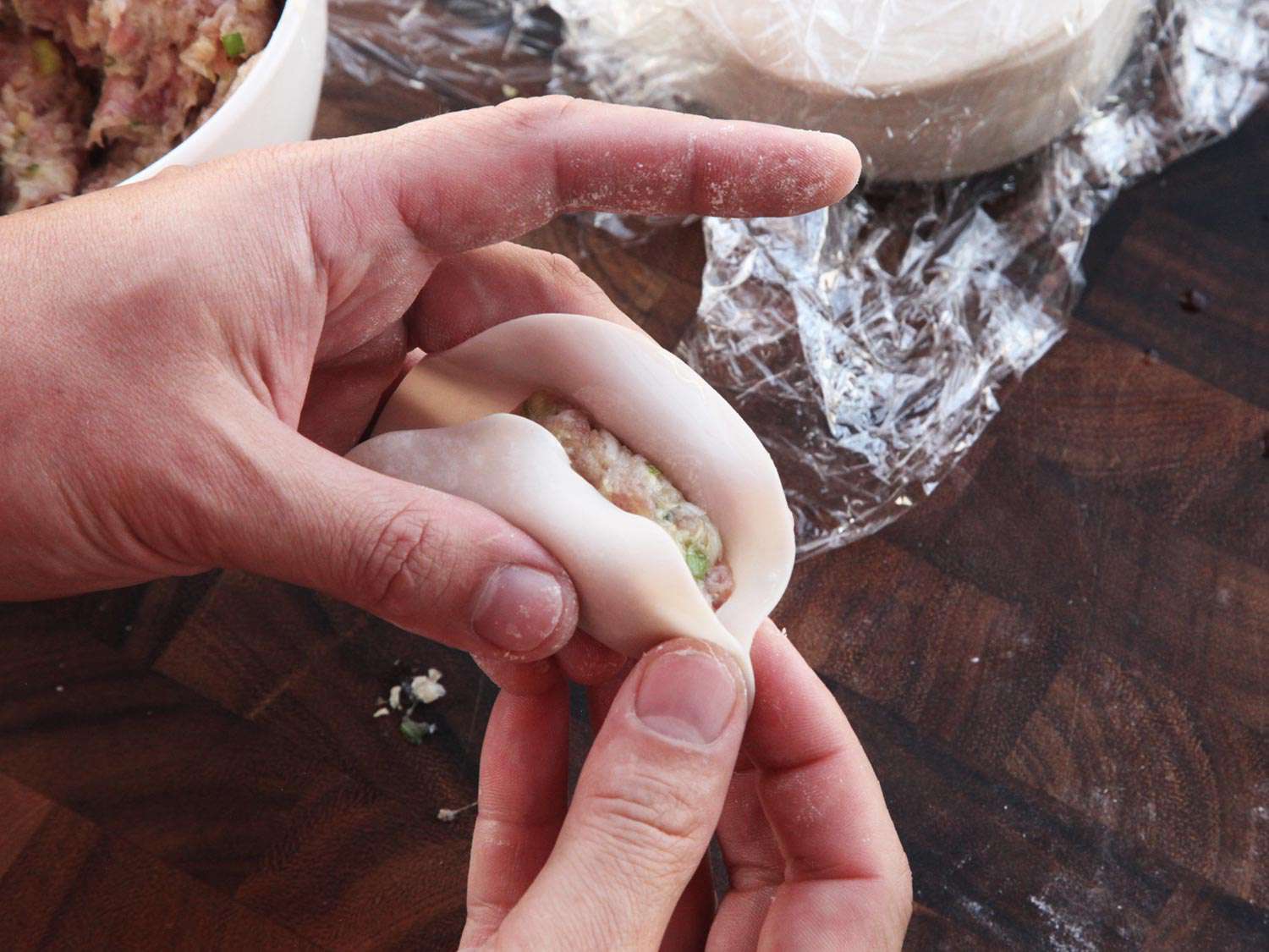 用猪肉和卷心菜馅的圆饺子皮包起来。