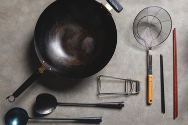 A top-down view of a wok and accessories arranged neatly on a table