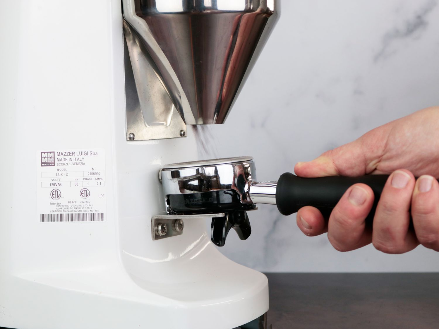 从Mazzer Lux D研磨机中取出的咖啡放入便携式过滤篮中