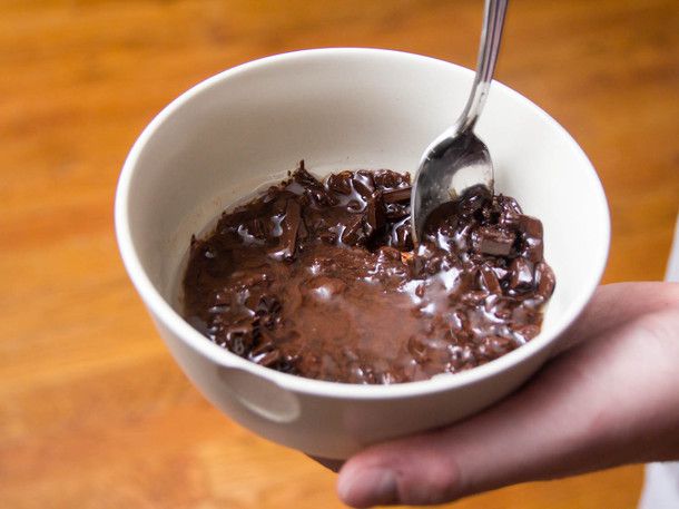 作者将部分融化的碎巧克力与椰子油和玉米糖浆放在一个小碗里搅拌。gydF4y2Ba