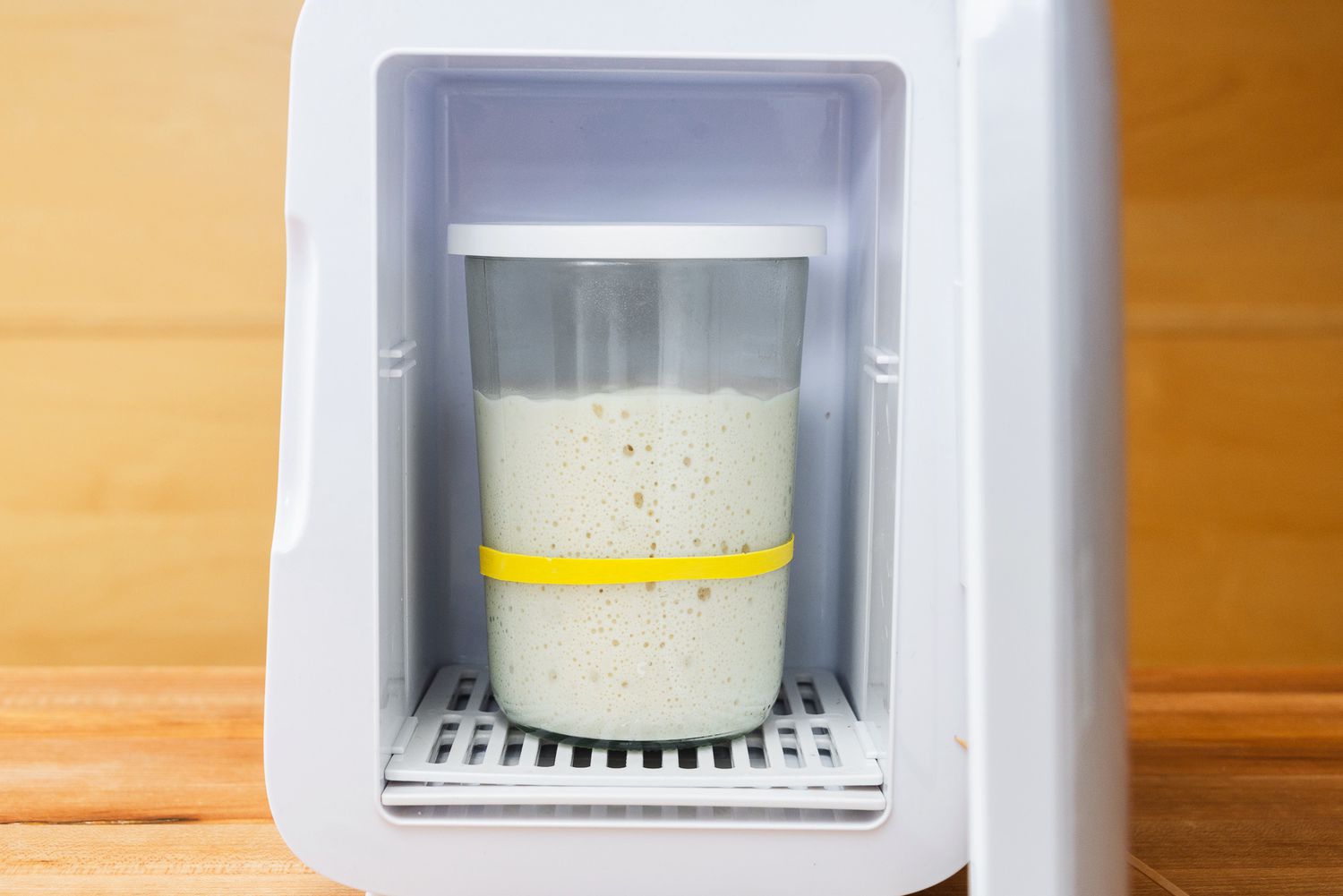 a jar of sourdough starter inside of the sourdough home