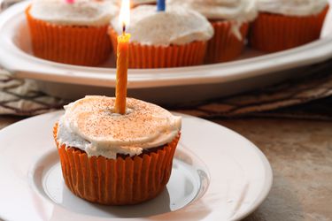 Frosted Gluten-Free Pumpkin Spice Cupcakes decorated with birthday candles