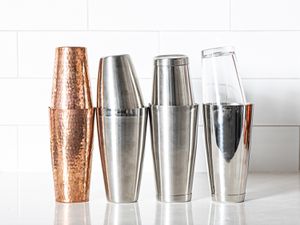 four boston shakers (made of different materials) on a grey countertop