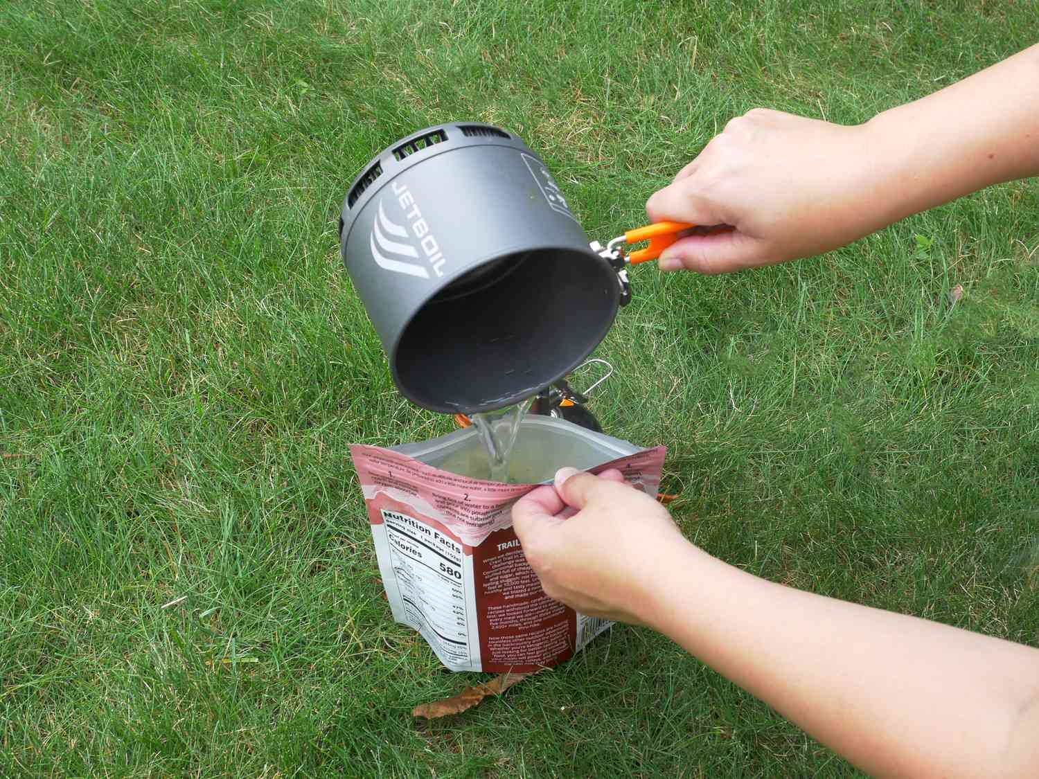 pouring hot water into a pouch of food