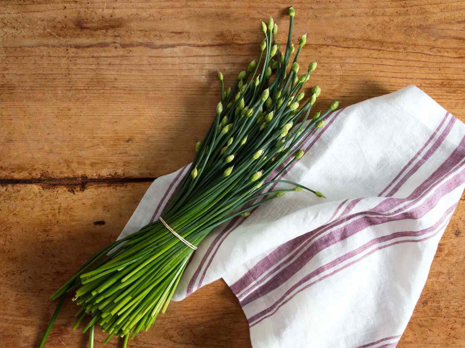 Bundle of flowering garlic chives on a table.