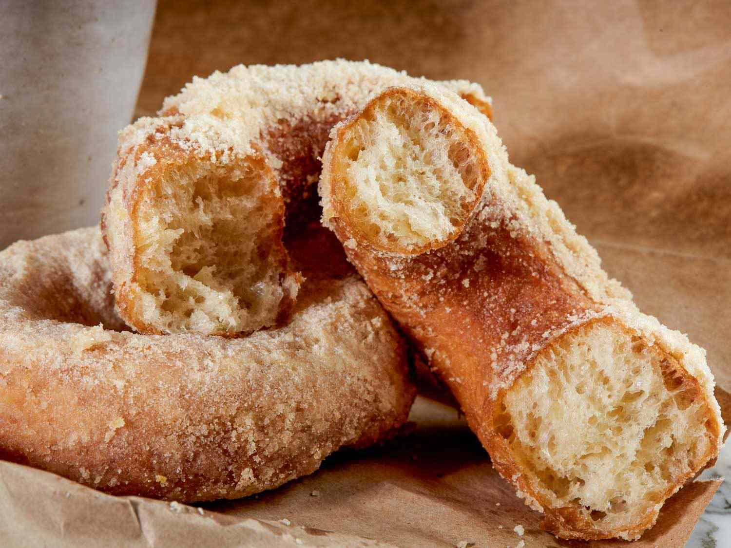 apple cider doughnut torn in half to reveal its interior crumb