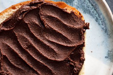 Overhead closeup of a slice of bread smothered with crispy homemade nutella.
