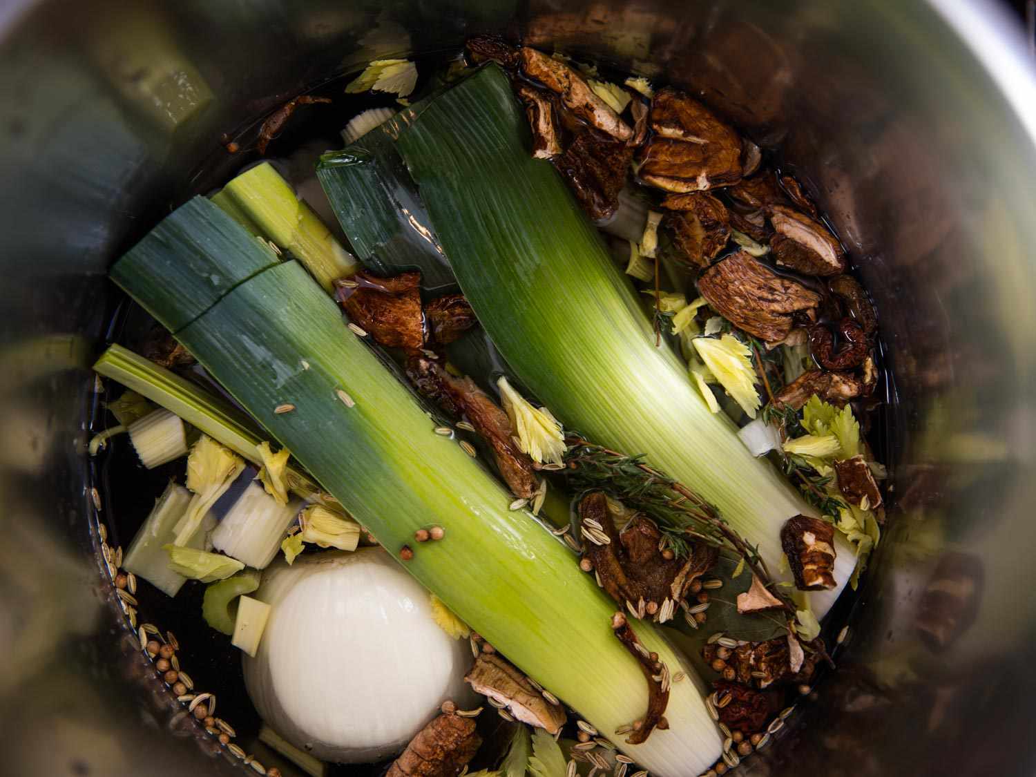 头顶上的照片，锅里装满了韭菜和其他做素食肉汤的配料华体会应用下载gydF4y2Ba