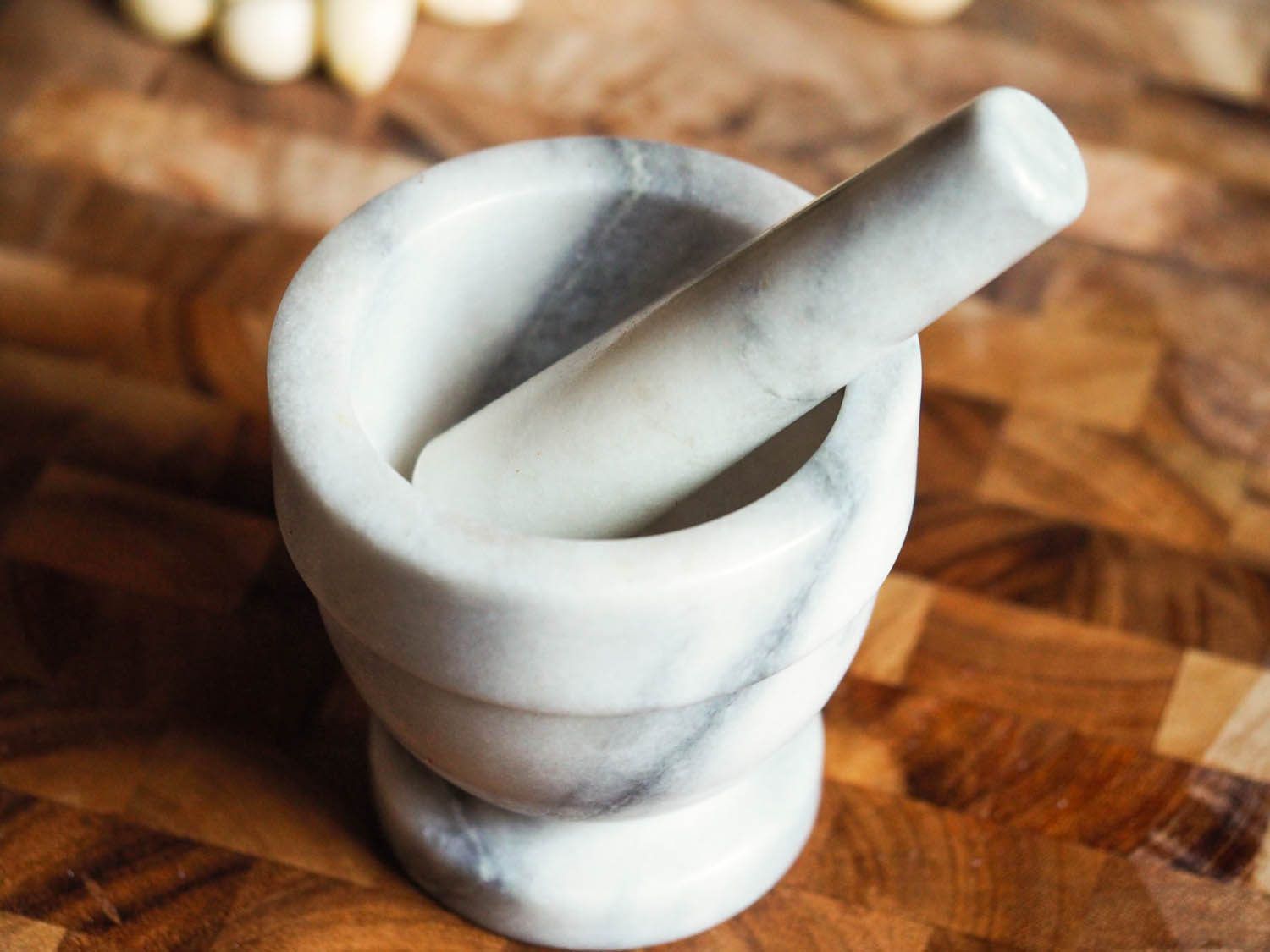 A mortar and pestle on a cutting board.