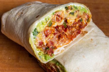 Cross section of a breakfast burrito with chorizo, egg, and refried beans.