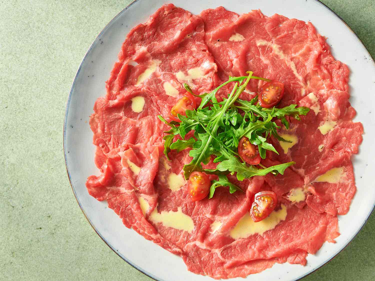 beef carpaccio garnished with tomato quarters