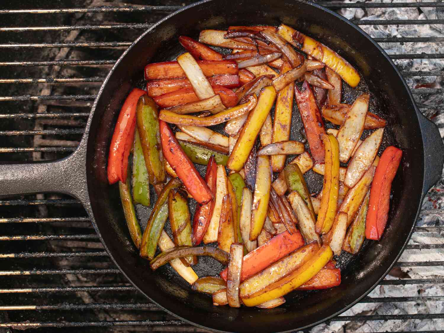 辣椒和洋葱在铸铁煎锅上木炭烧烤。
