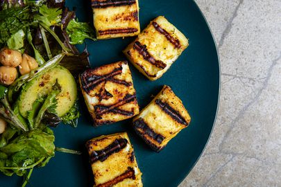 Cropped view of grilled paneer and chickpea salad on a blue plate