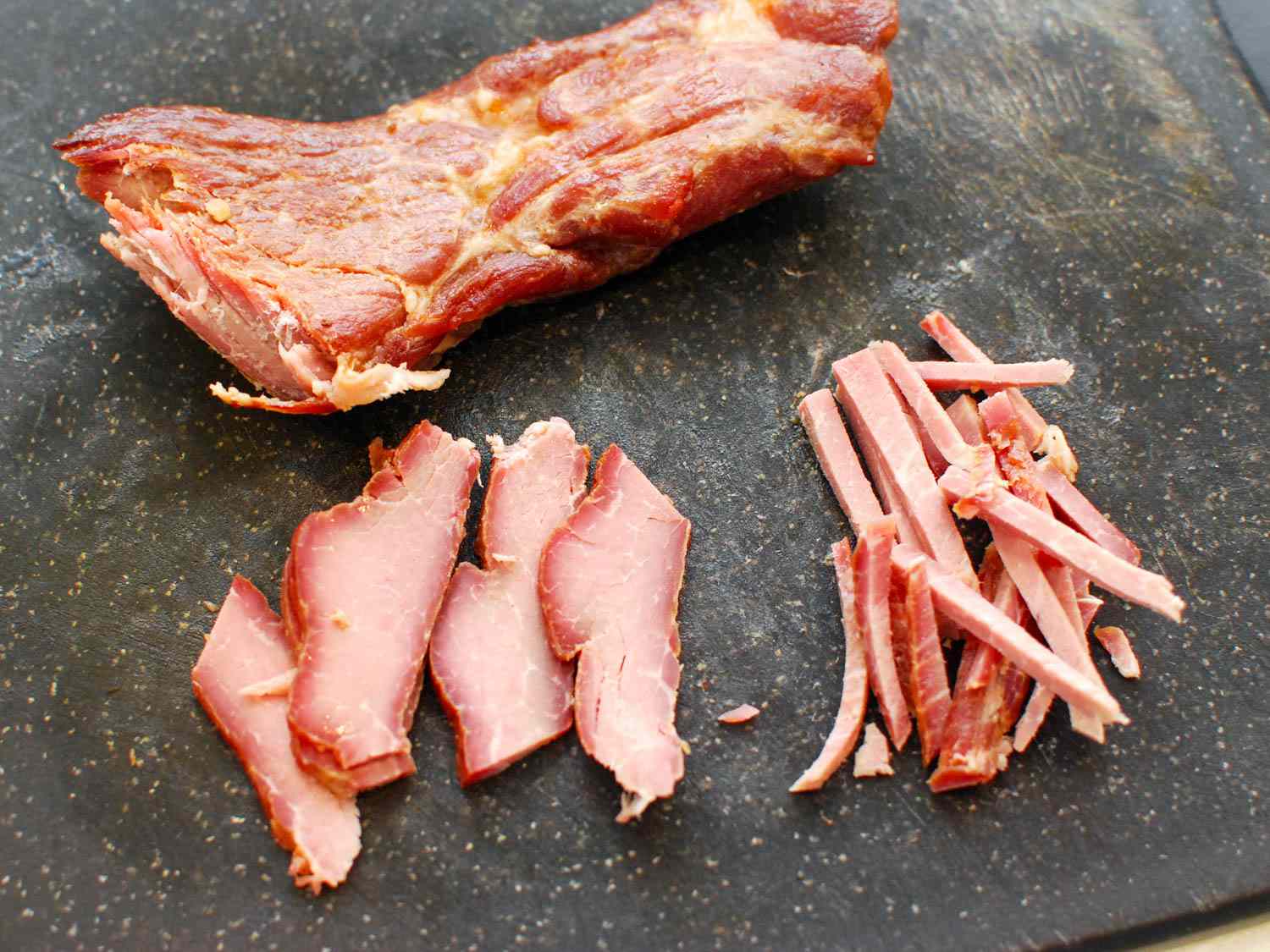 Sliced char siu resting on a cutting board.