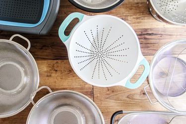 an overhead shot of a number of colanders on a wooden surface