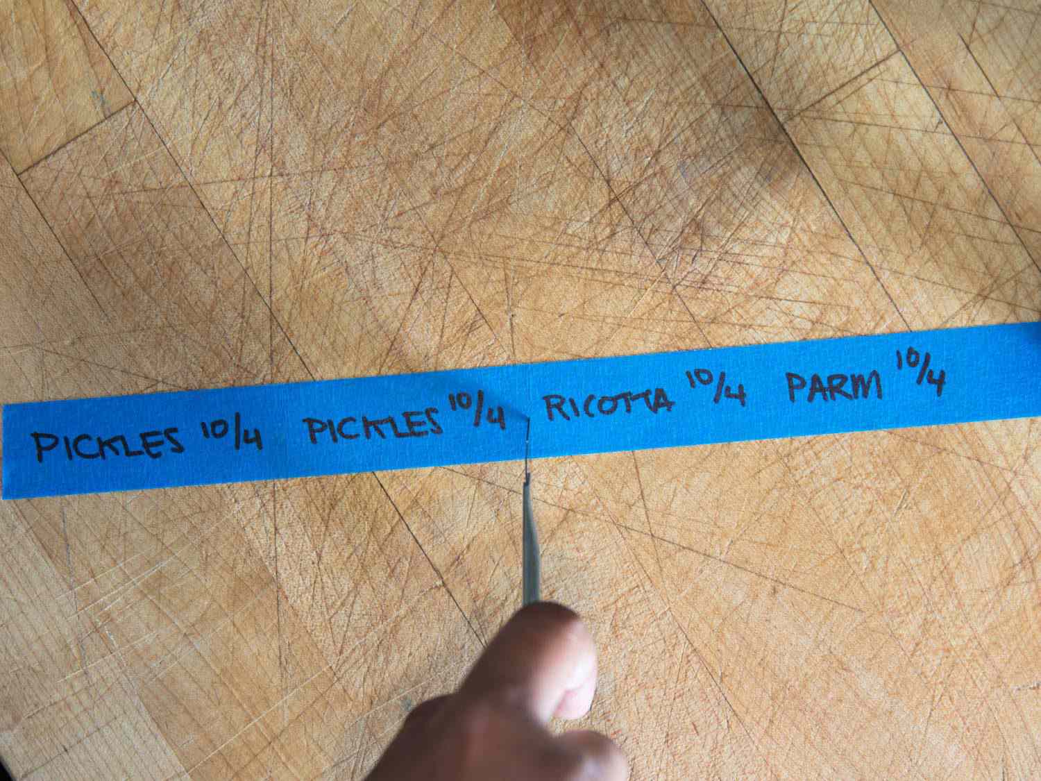 一段有标签标记的蓝色油漆工胶带，被切成单独的标签