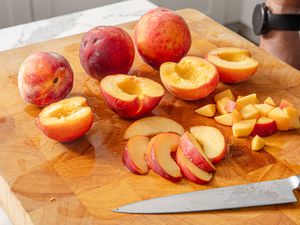 Side view of peaches on a cutting board