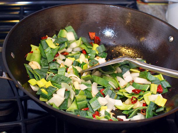 将韭菜放入放入辣椒和大蒜的锅中。