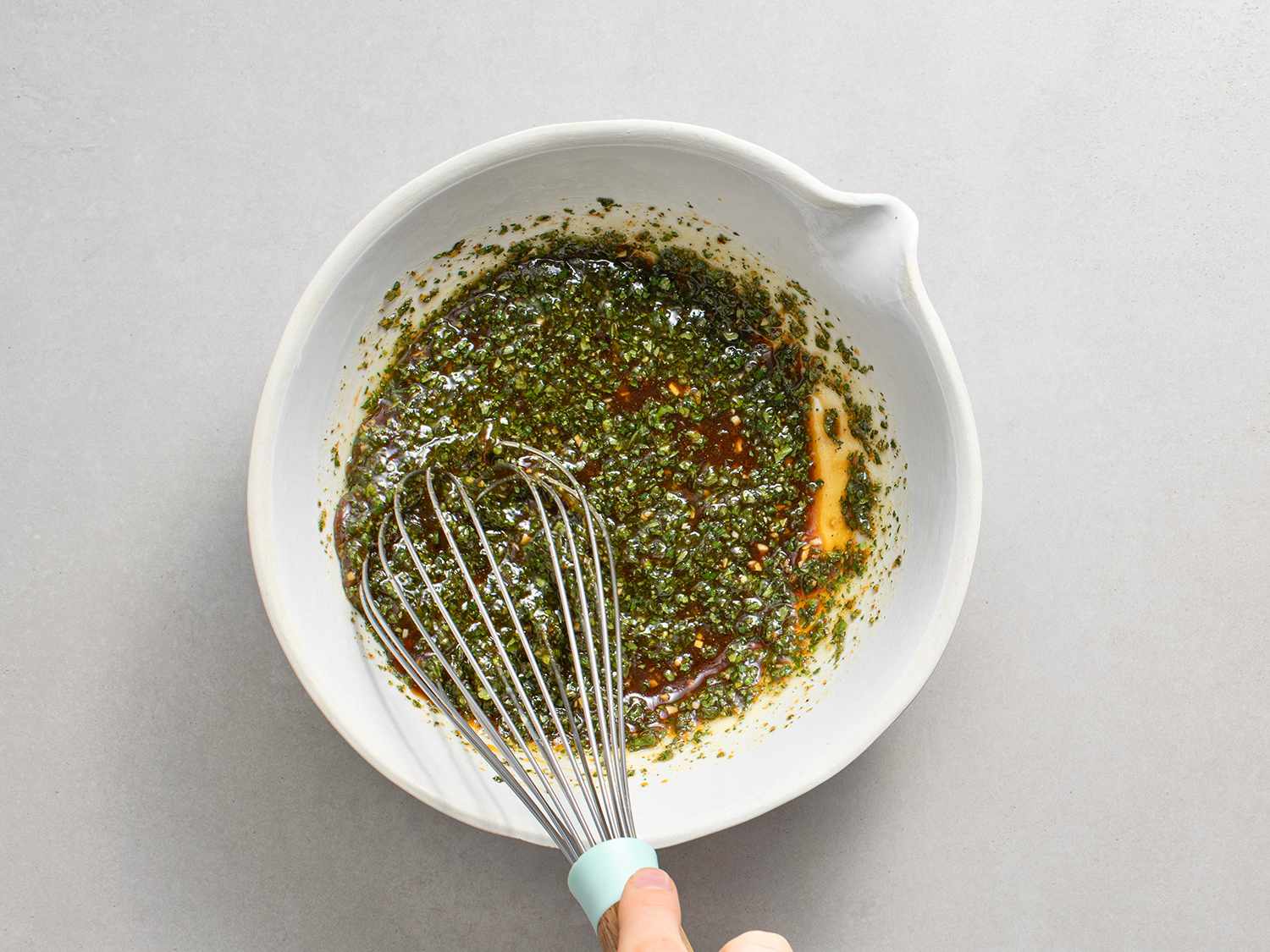 Mojo and pork juices being whisked in a bowl