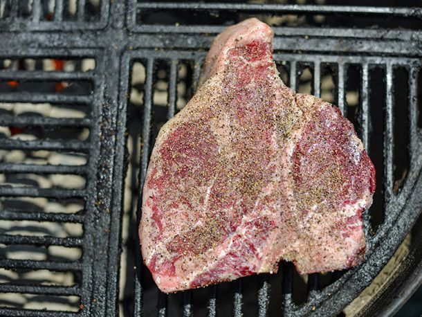 一个生的，经过调味的上等腰肉被放在烤架上较冷的一侧，并确定方向，使里脊肉比长条里脊肉离煤更远。