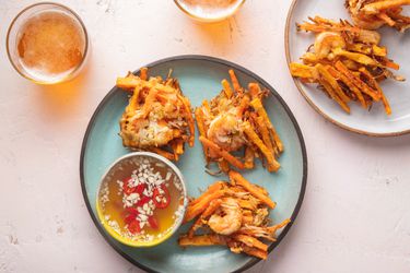 Filipino Ukoy fritters on a a blue plate with dipping sauce and beer on the side