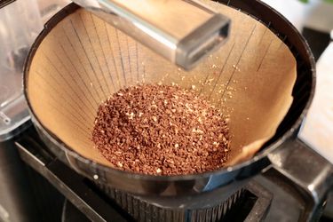 A closeup shot of coffee grounds placed in a filter in a brew basket