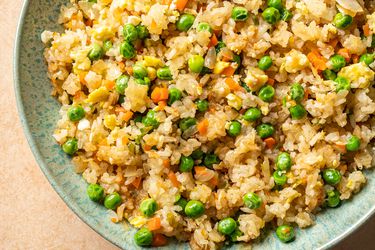 Vegetable fried rice inside a green ceramic bowl.