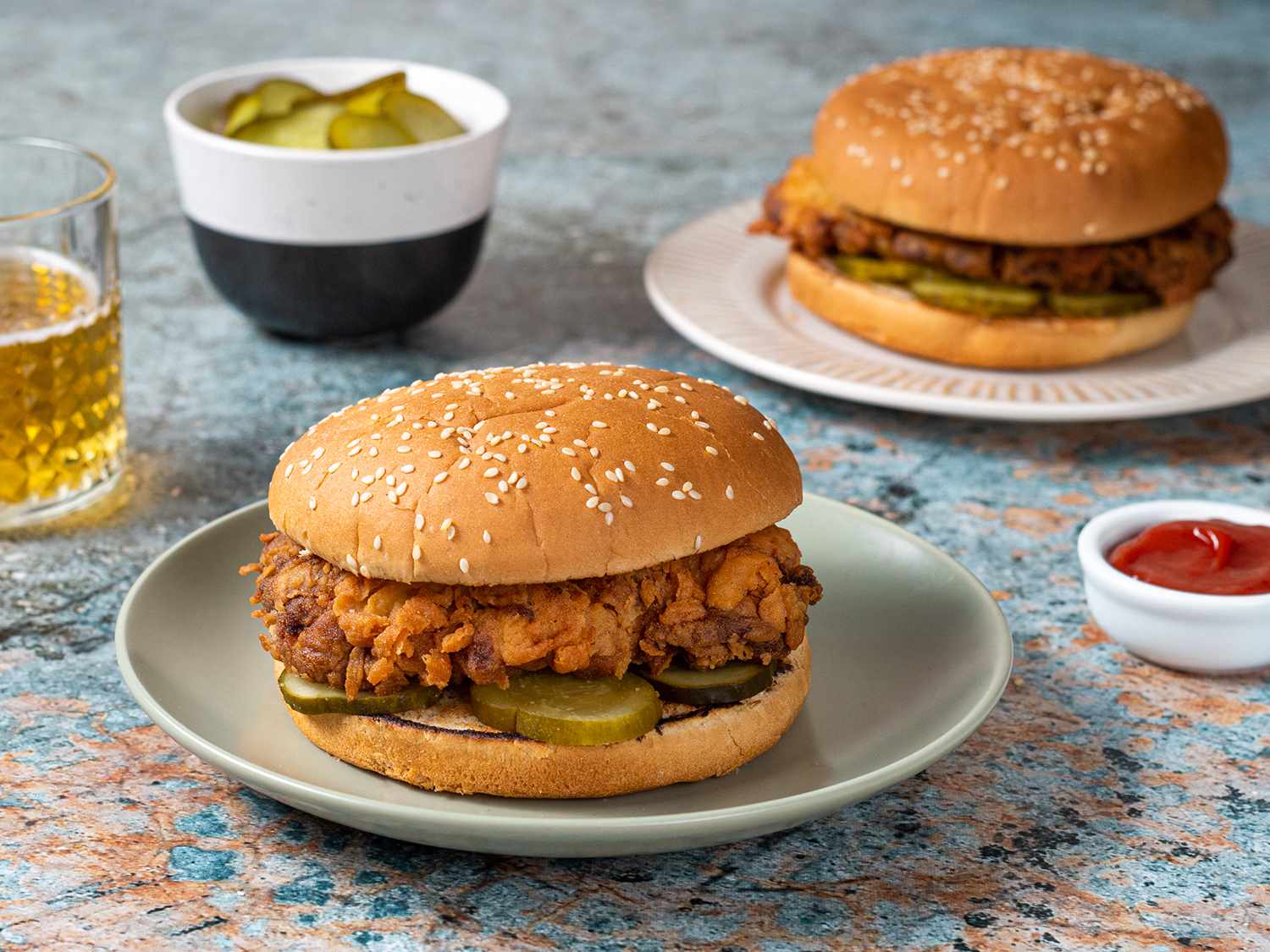 Two fried chicken sandwiches on ceramic plates.