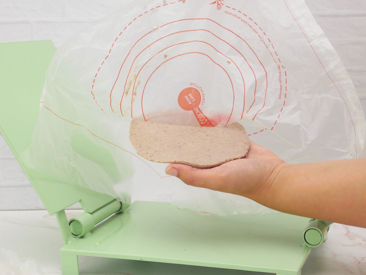 pulling the liner off a freshly pressed tortilla