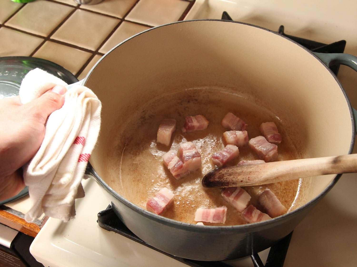 Browning diced pork belly in a Dutch oven for cassoulet.