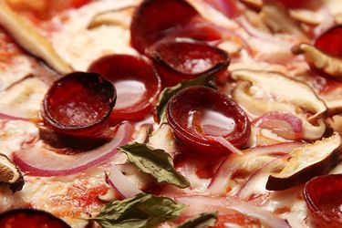 烤熟的卷意大利辣香肠，披萨表面有一小滩脂肪。