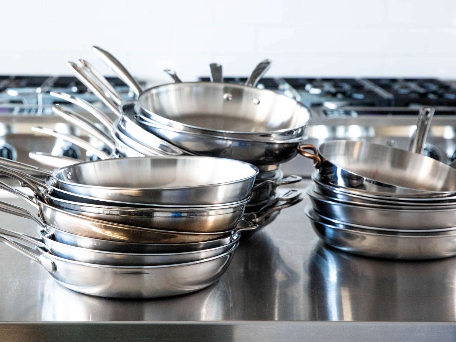 three stacks of stainless steel skillets