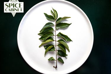 Curry leaves on a plate with Spice Cabinet badge