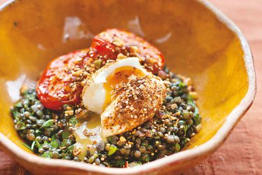 A bowl of lentils with roasted tomatoes with Dukka-crumbed egg
