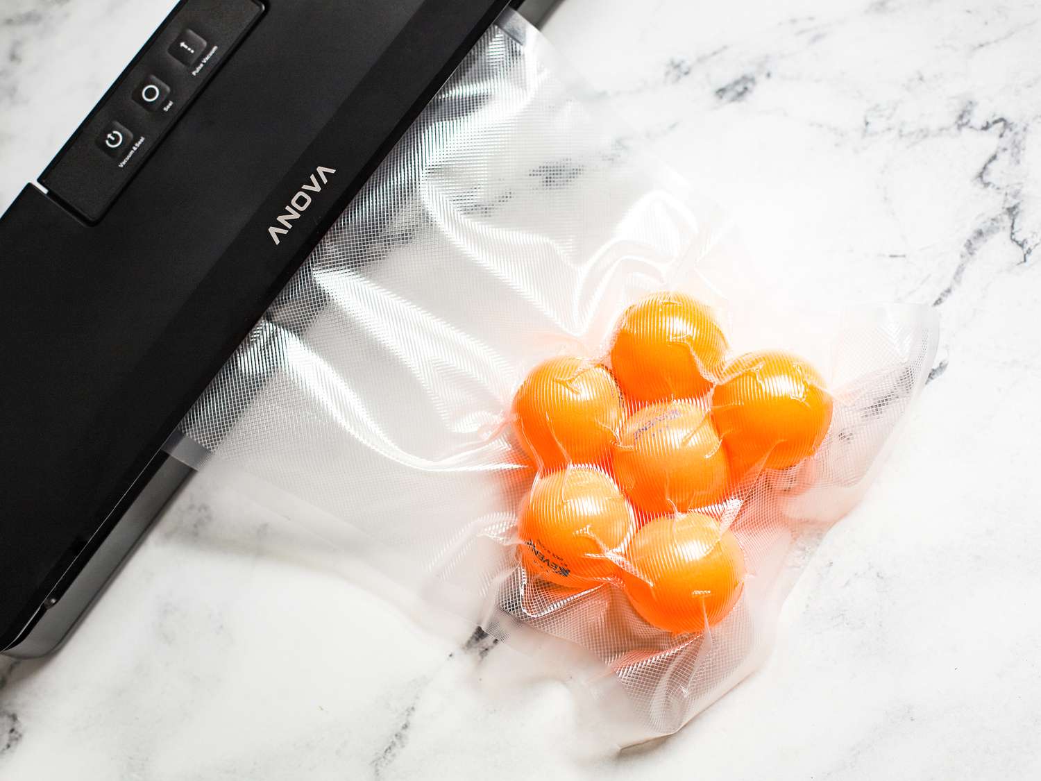 A vacuum sealer sealing a bag with six ping pong balls in it