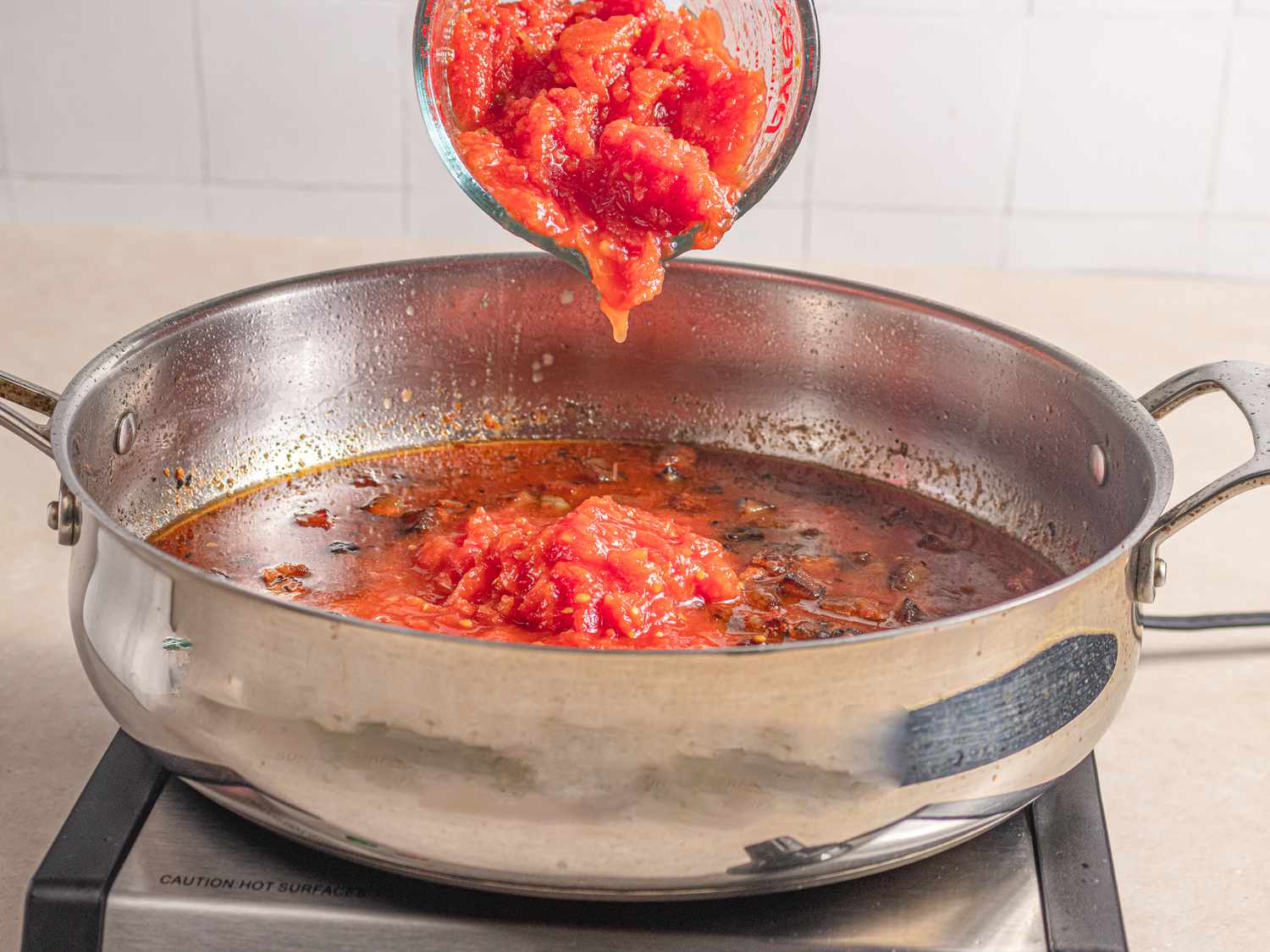 Adding tomatoes to pan