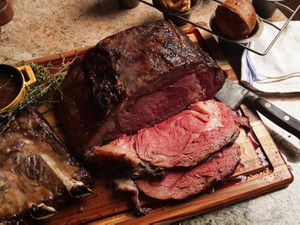 A sliced prime rib on a wooden carving board