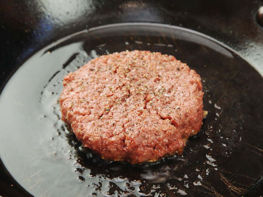 由Beyond burger制成的调味汉堡肉饼，在铸铁煎锅中煎制。