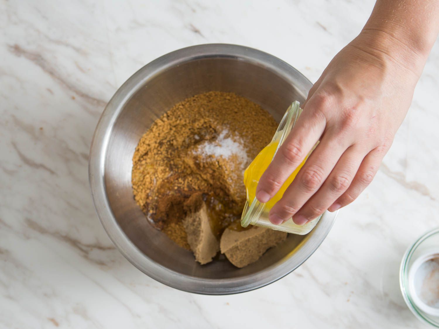 将融化的黄油倒入一碗饼干屑和糖中，做成南瓜芝士蛋糕的皮。