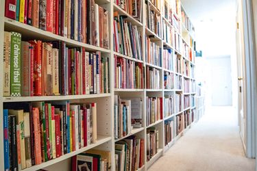 Bookshelves holding hundreds and hundreds of cookbooks.