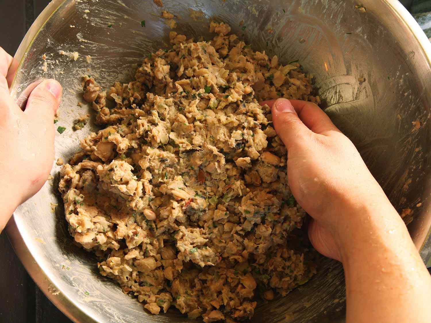 在一个大碗里用手搅拌豆子和蘑菇的混合物。