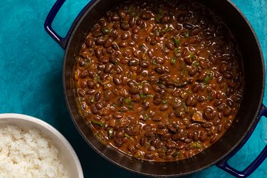 a dutch oven with Kenyan njahi beans in a coconut sauce with a bowl of white rice to the side