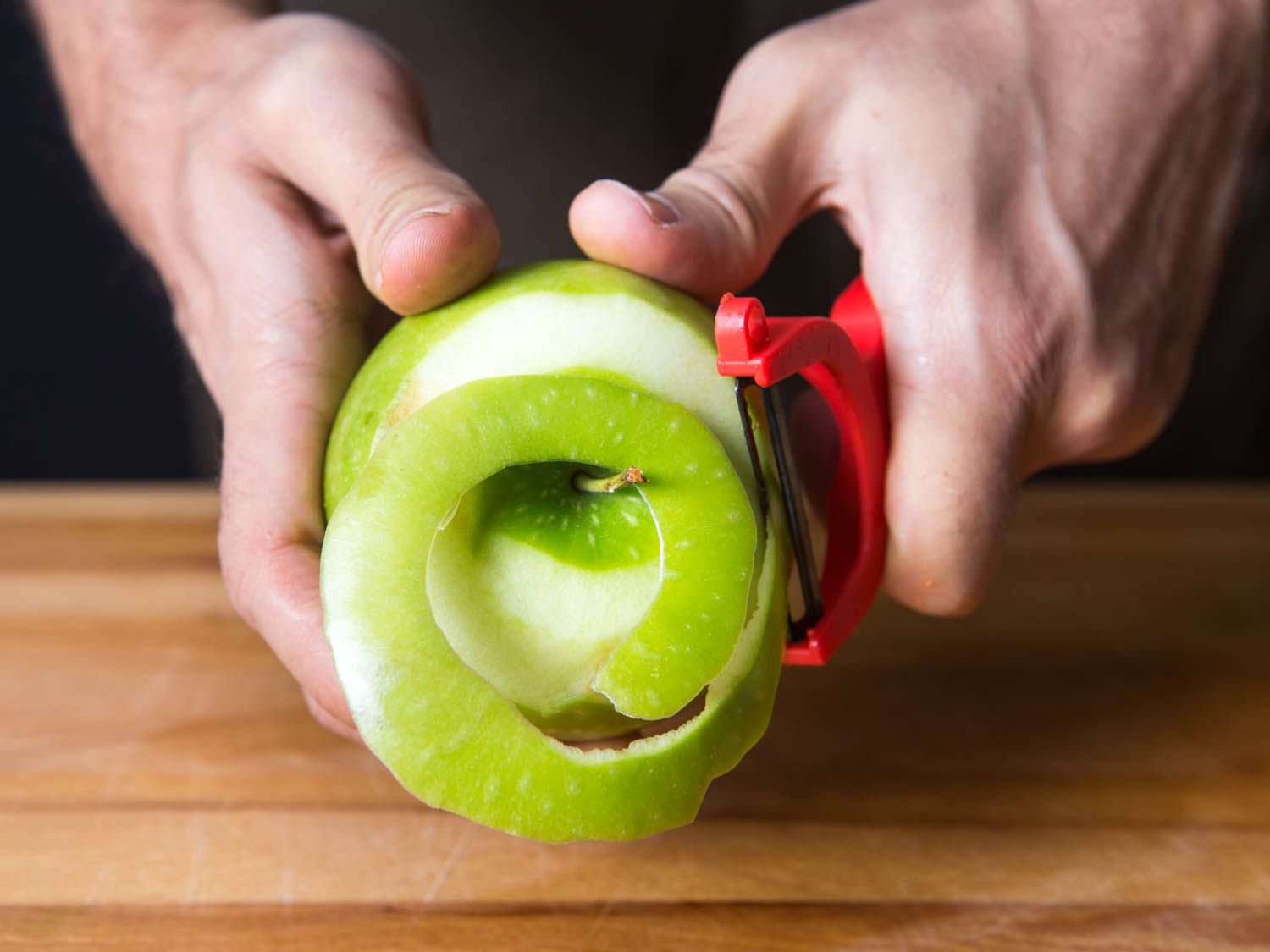 A y-peeler peeling an apple