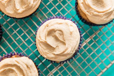 Overhead closeup of cupcakes on a cooling rack topped with easy peanut butter frosting.