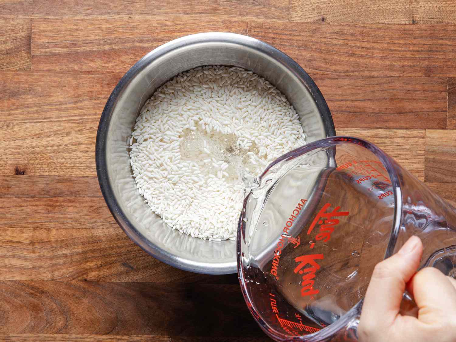 往一碗米饭里倒水的俯视图