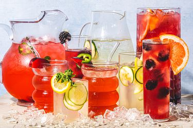 Multiple pitchers and glasses filled with infused water