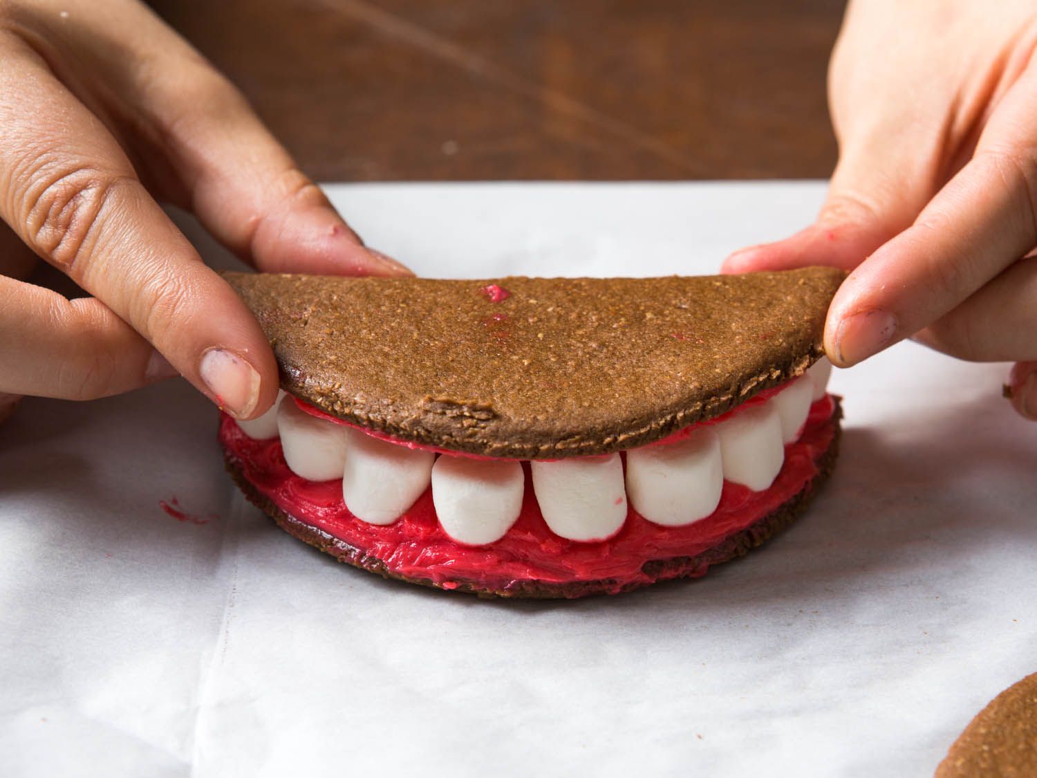 Placing on top half of vampire teeth sandwich cookie.